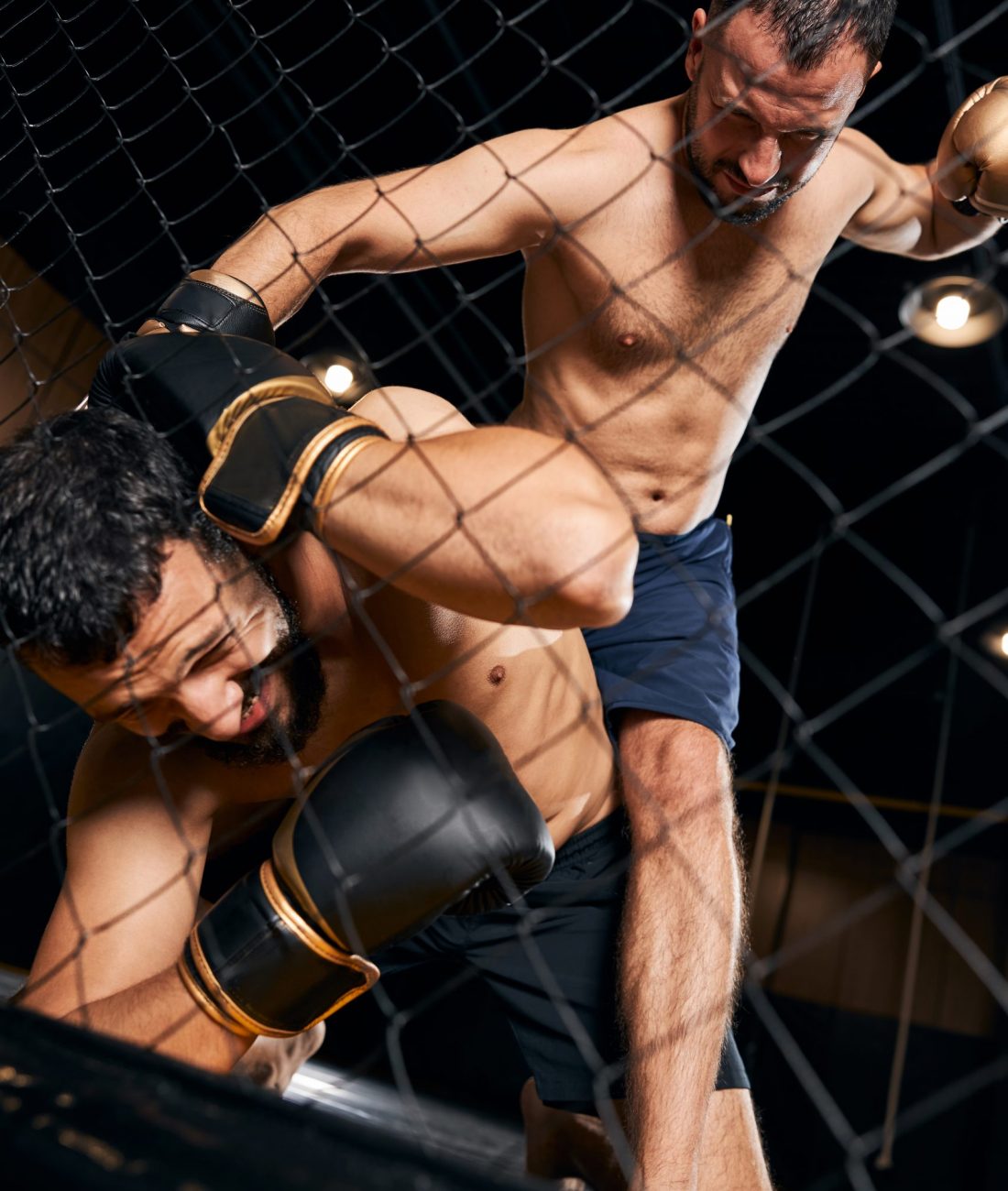 Cruel fighter sitting on a frightened man and beating him with his fists