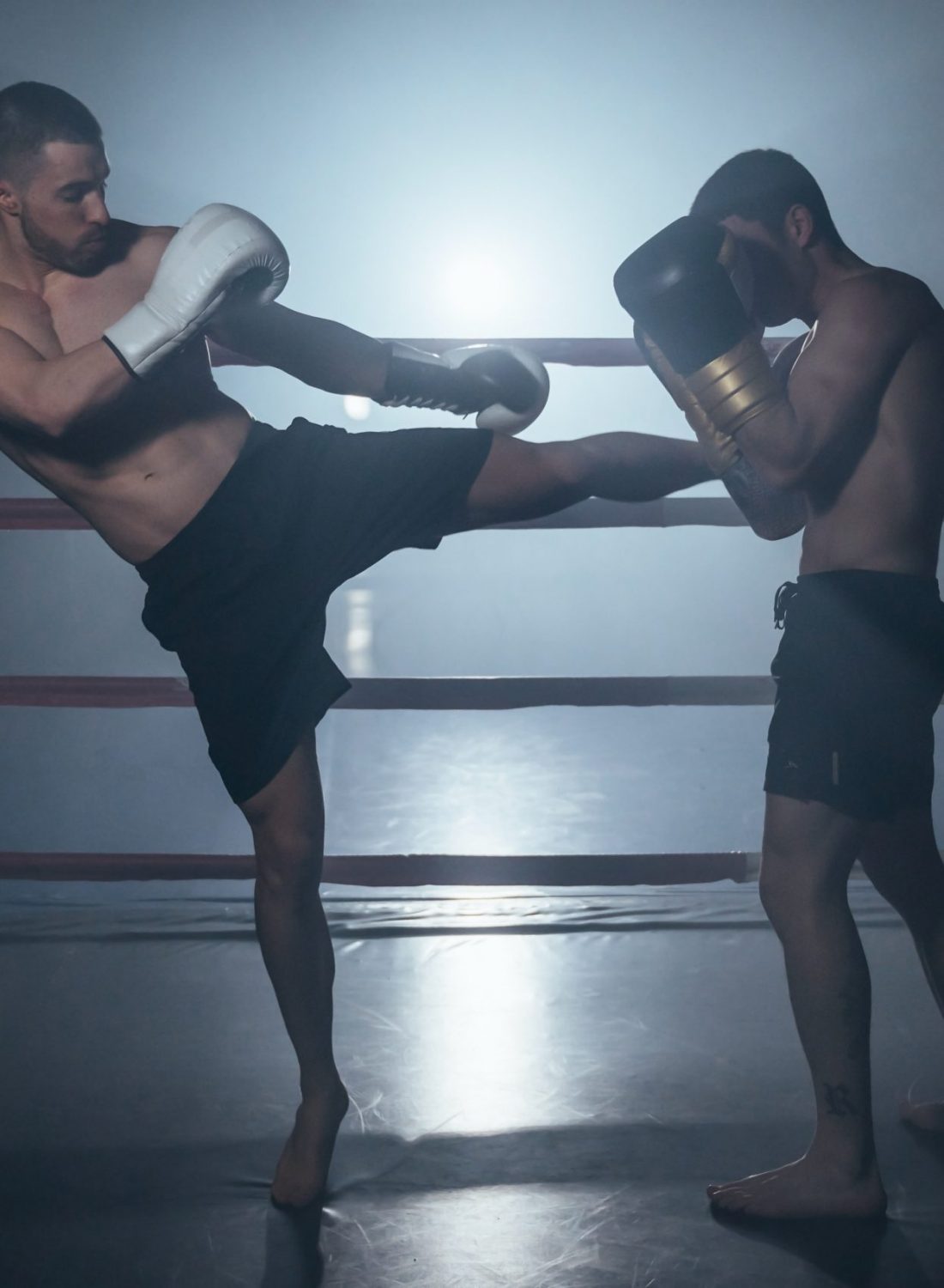 Two shirtless muscular man fighting Kick boxing combat in boxing ring. High quality photo
